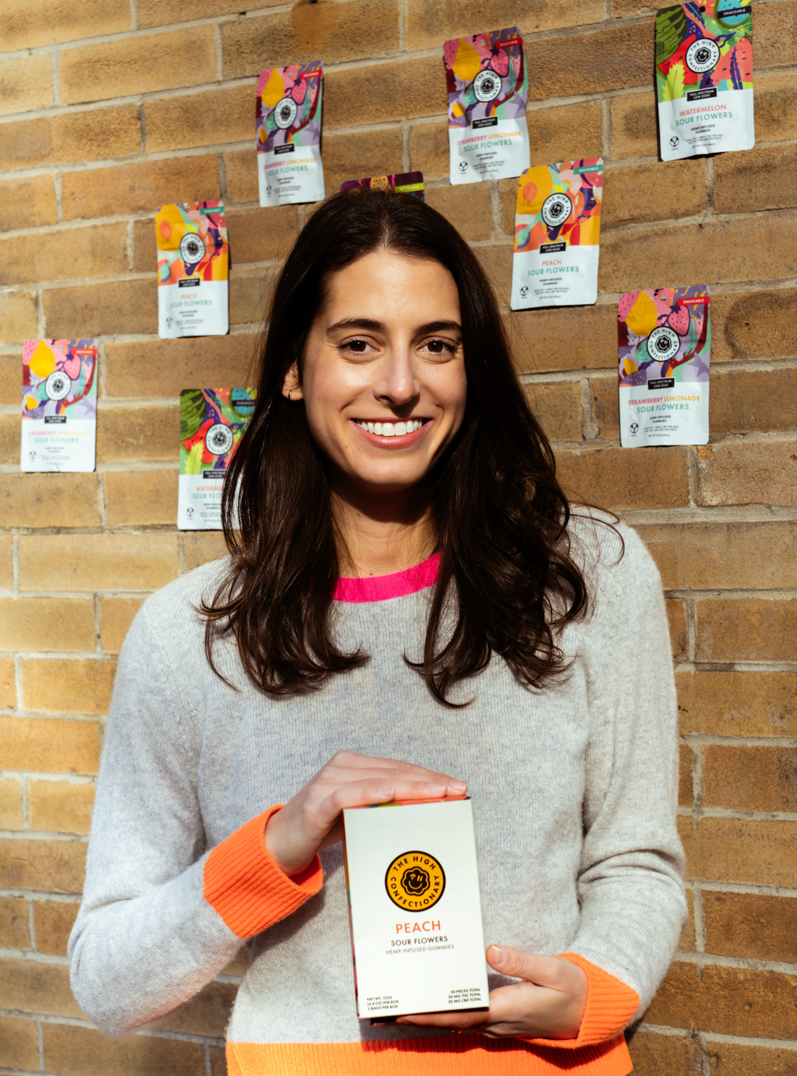 Founder and proud mom , Jenna Goldring, holding her microdose High Confectionary hemp edibles
